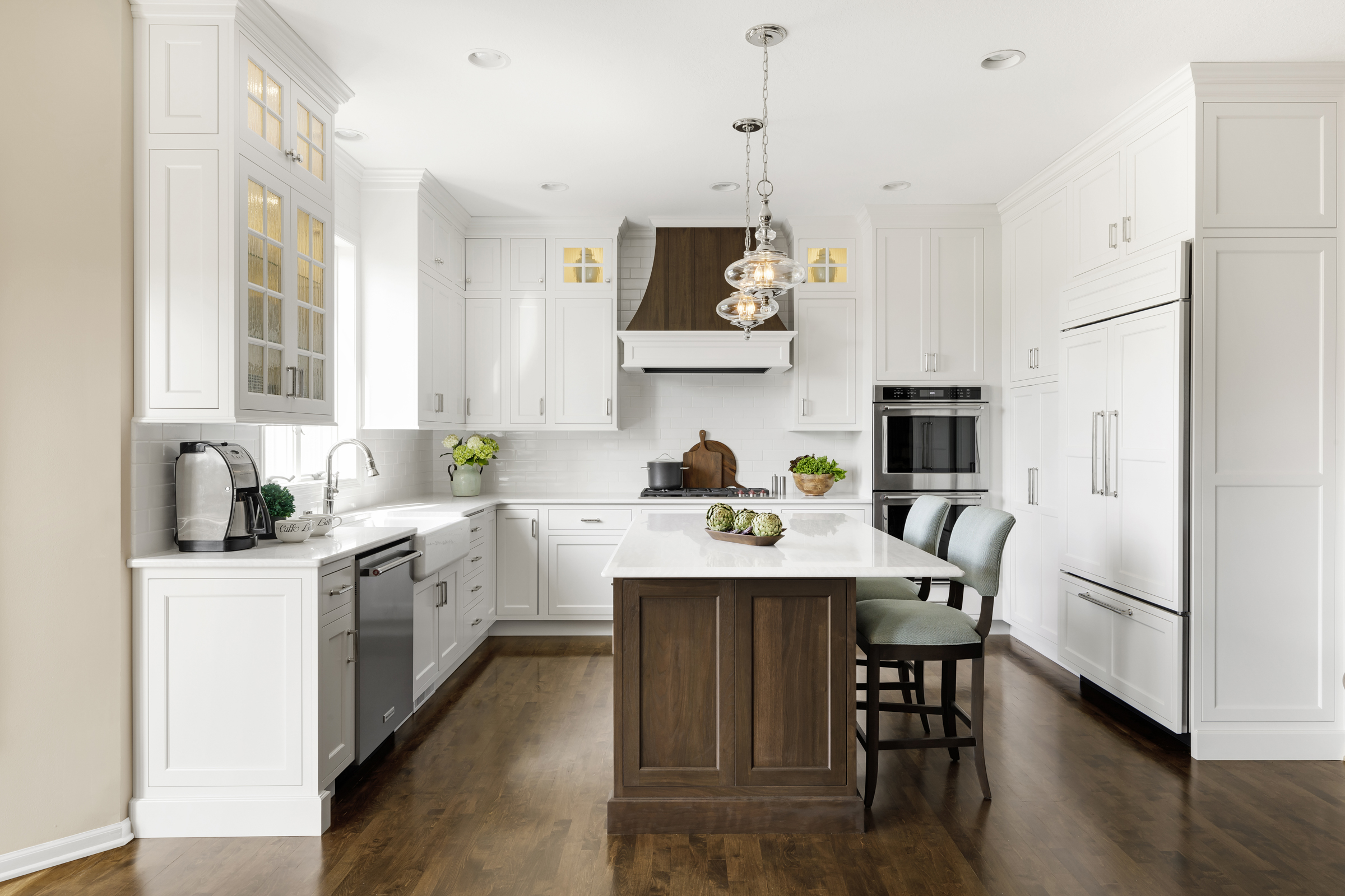 Kitchen remodel with large wooden island and white surrounding cabinets