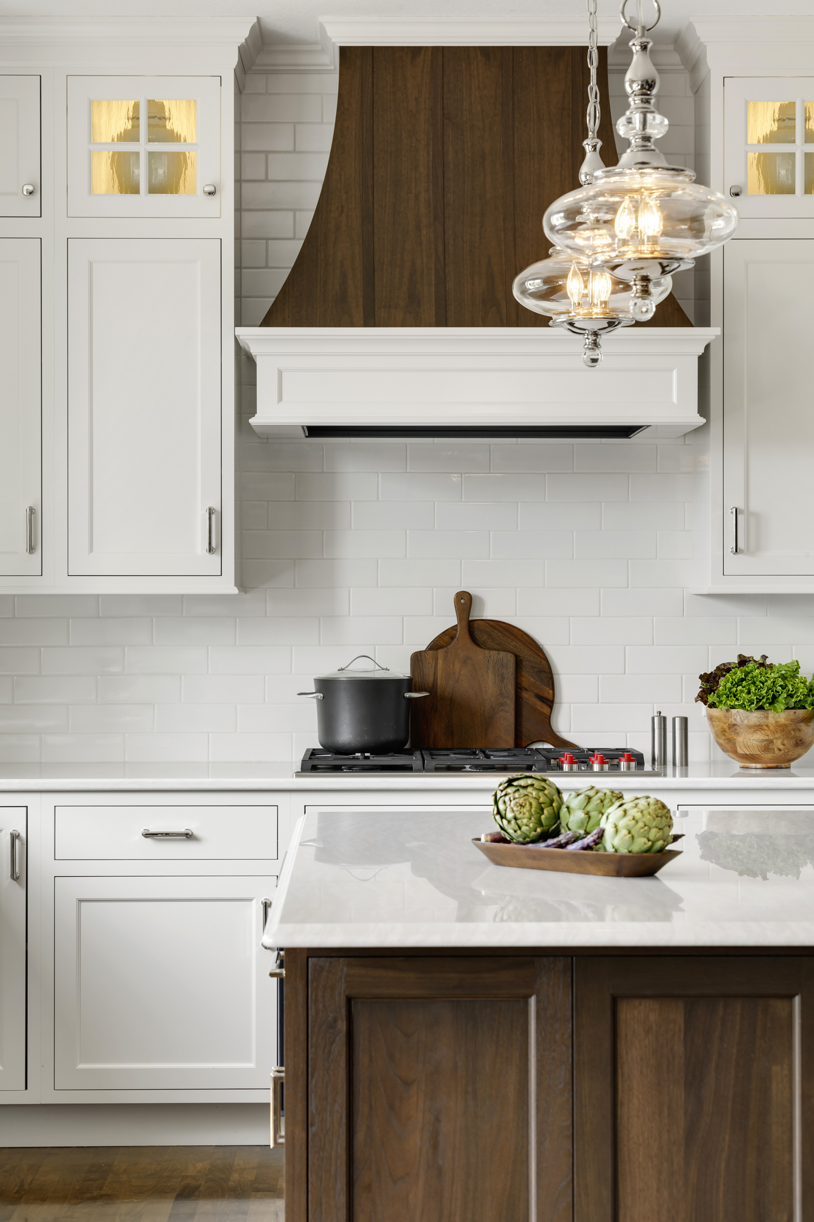 Kitchen remodel with custom wood range hood and white surrounding cabinets