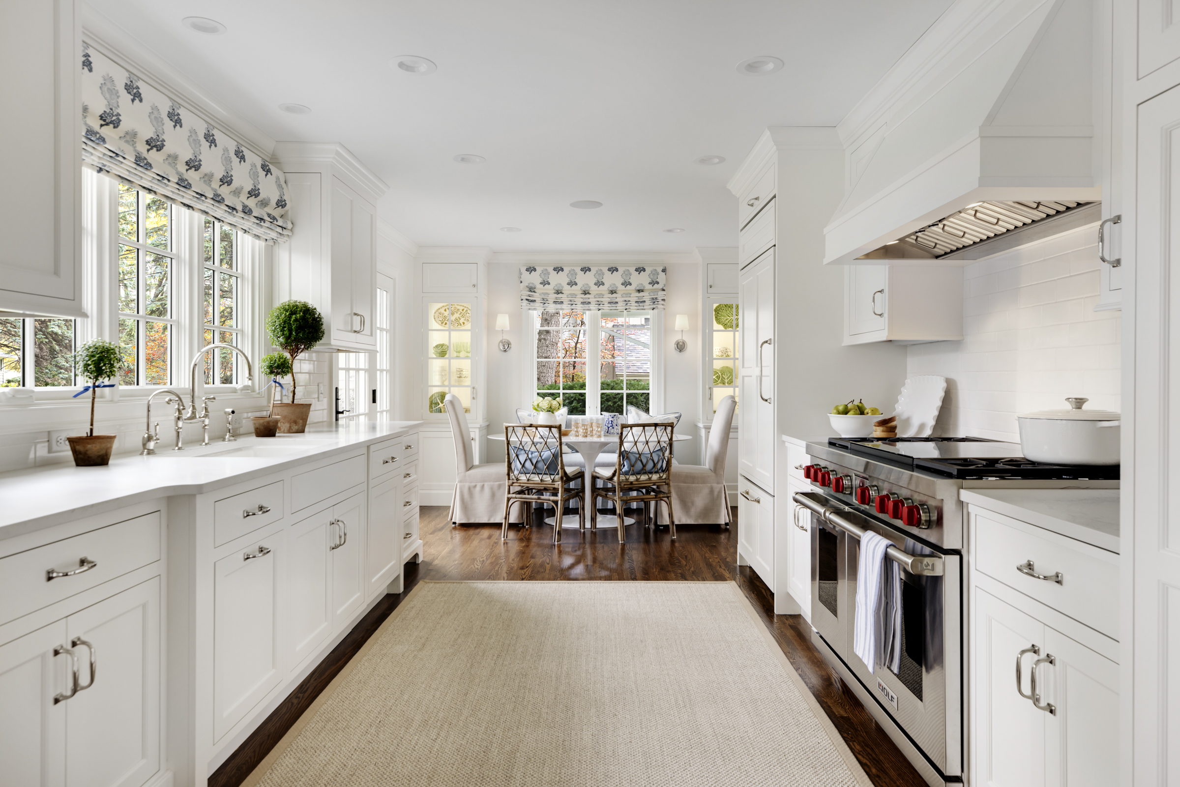 Charming kitchen remodel with white cabinets, high-end appliances, and breakfast nook