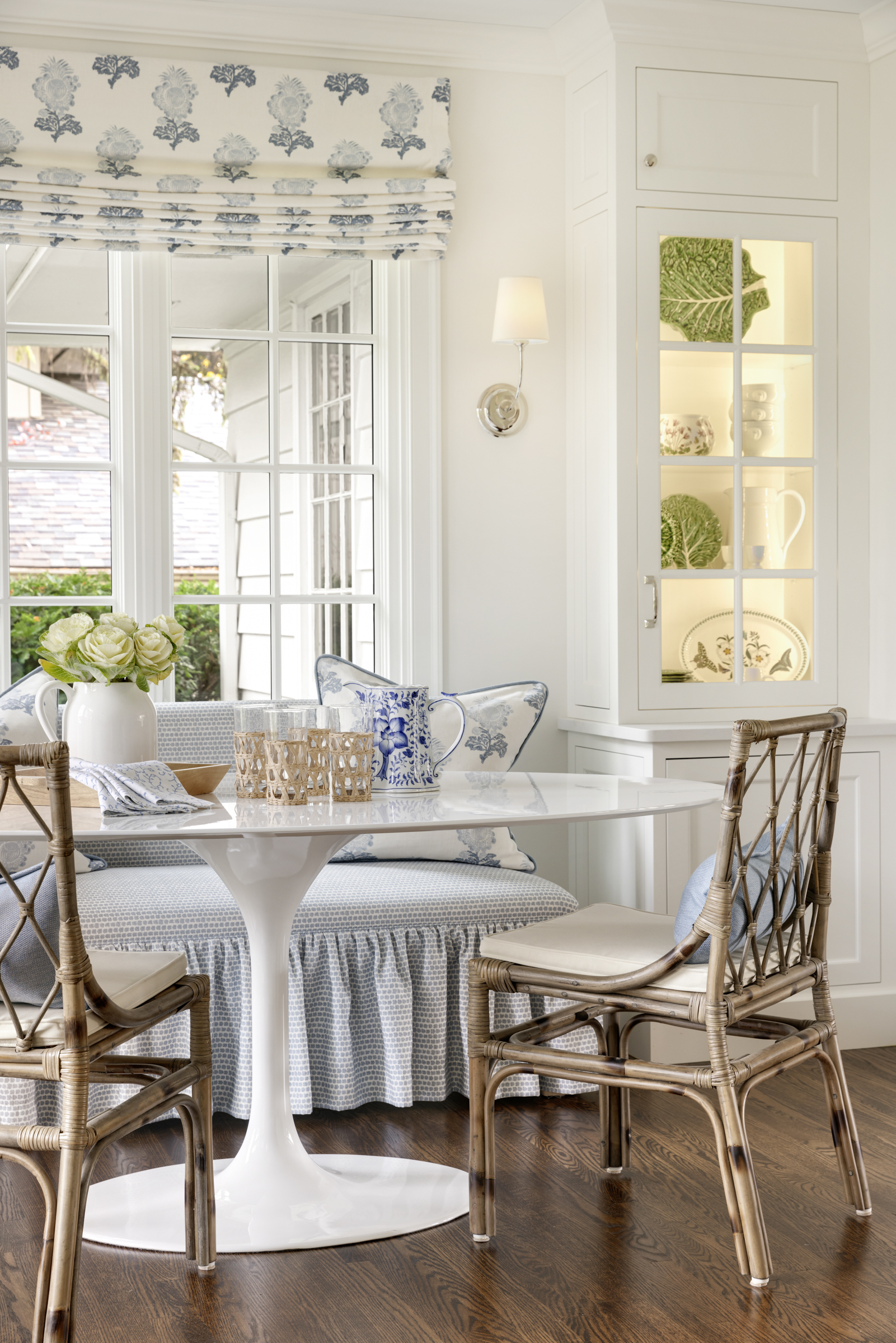 Charming kitchen remodel breakfast nook with booth seat under window and glass front storage
