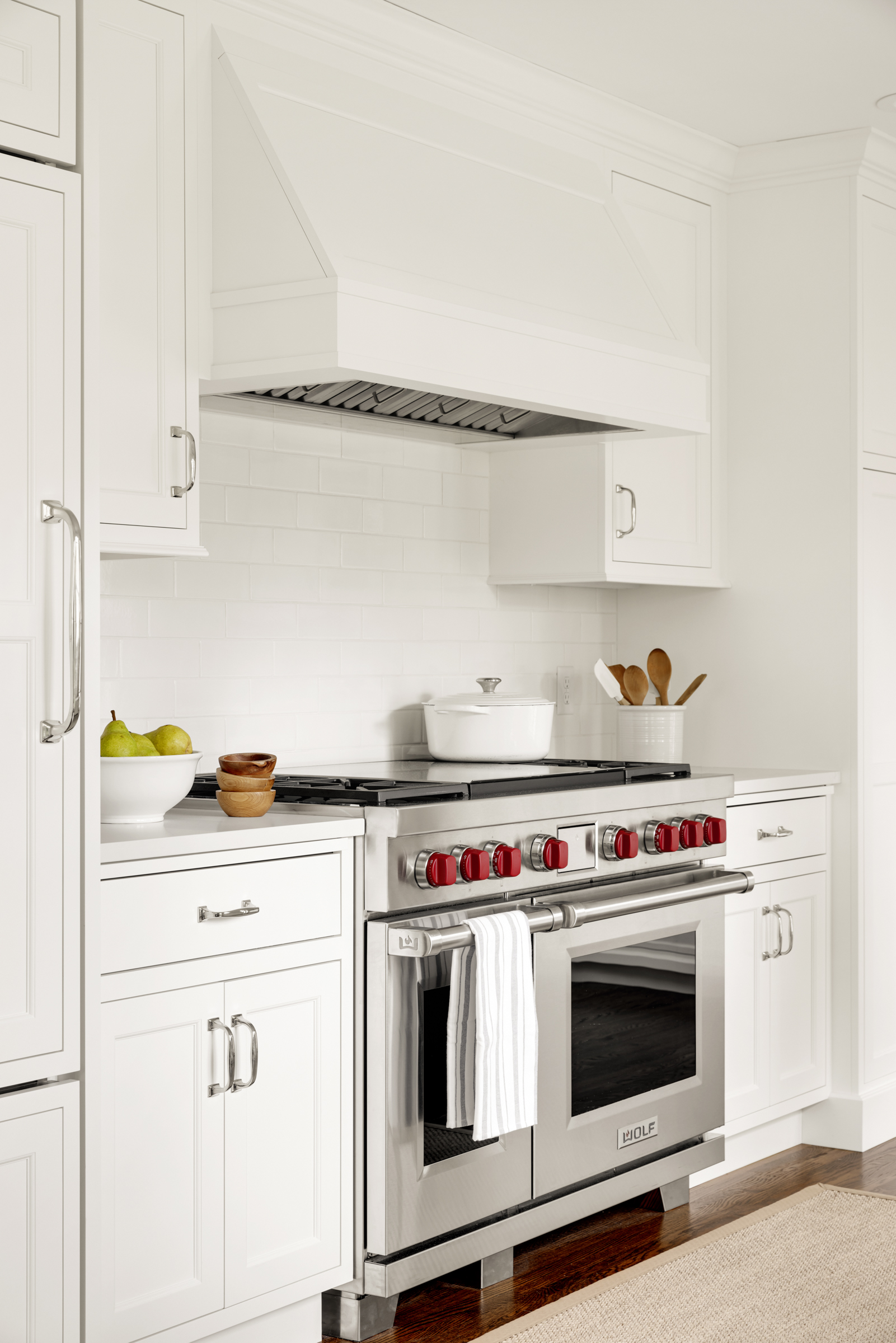 Charming kitchen remodel with white cabinets, white range hood, and high-end appliances