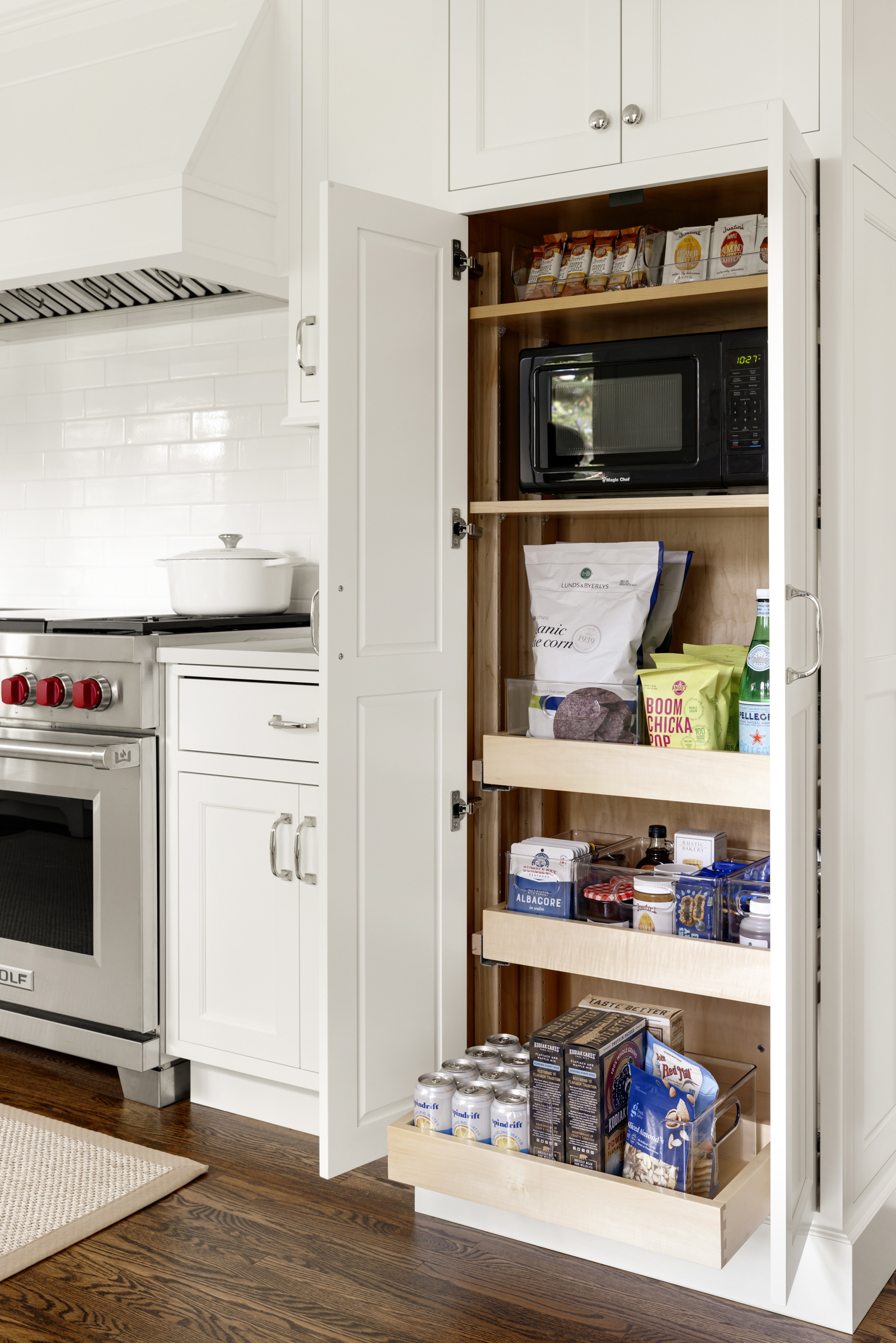 Kitchen renovation with large pantry cabinet with pull out shelving in kitchen remodel with white cabinets