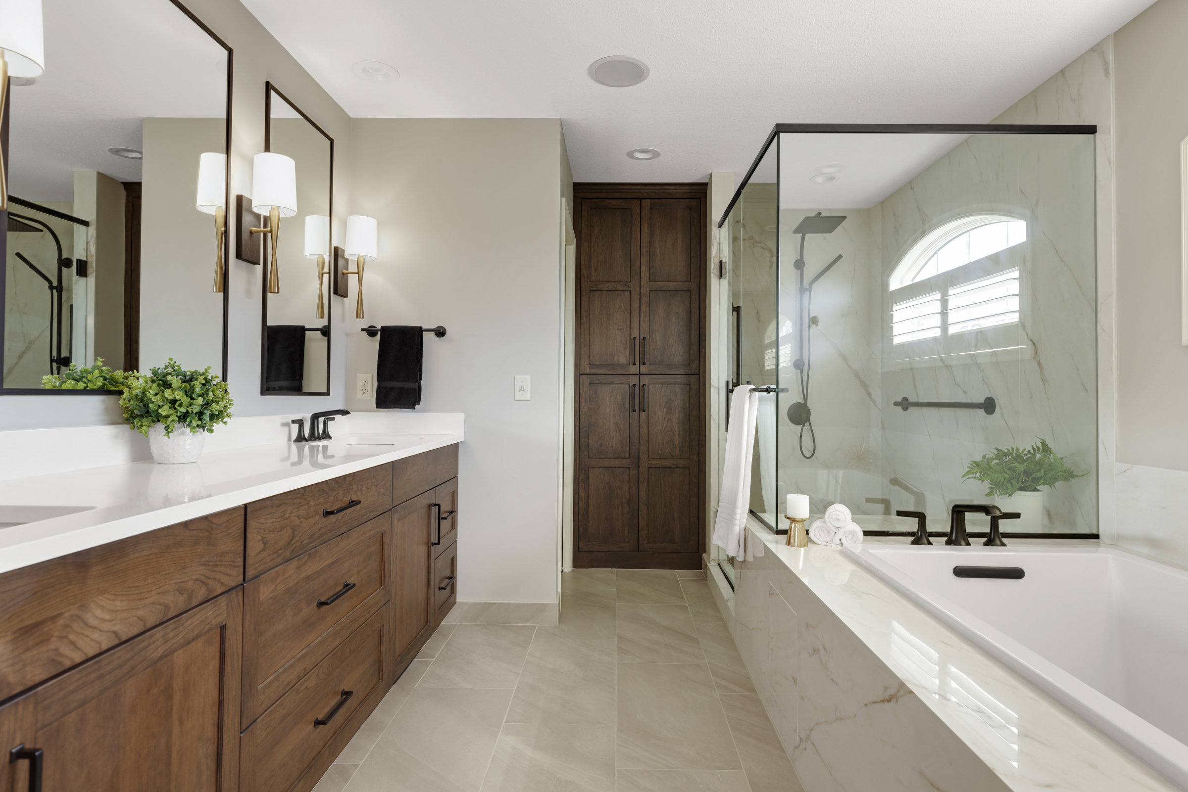 Remodeled primary Bathroom with wood cabinets and marble shower
