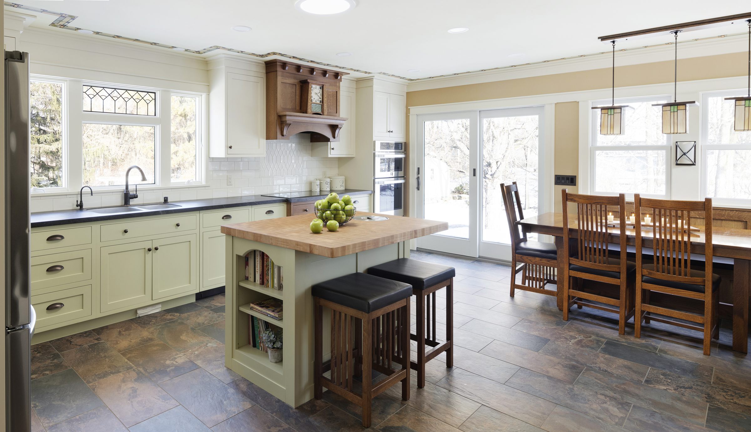 Craftsman kitchen remodel with butcher block island, built in dining seating, and double glass sliding doors