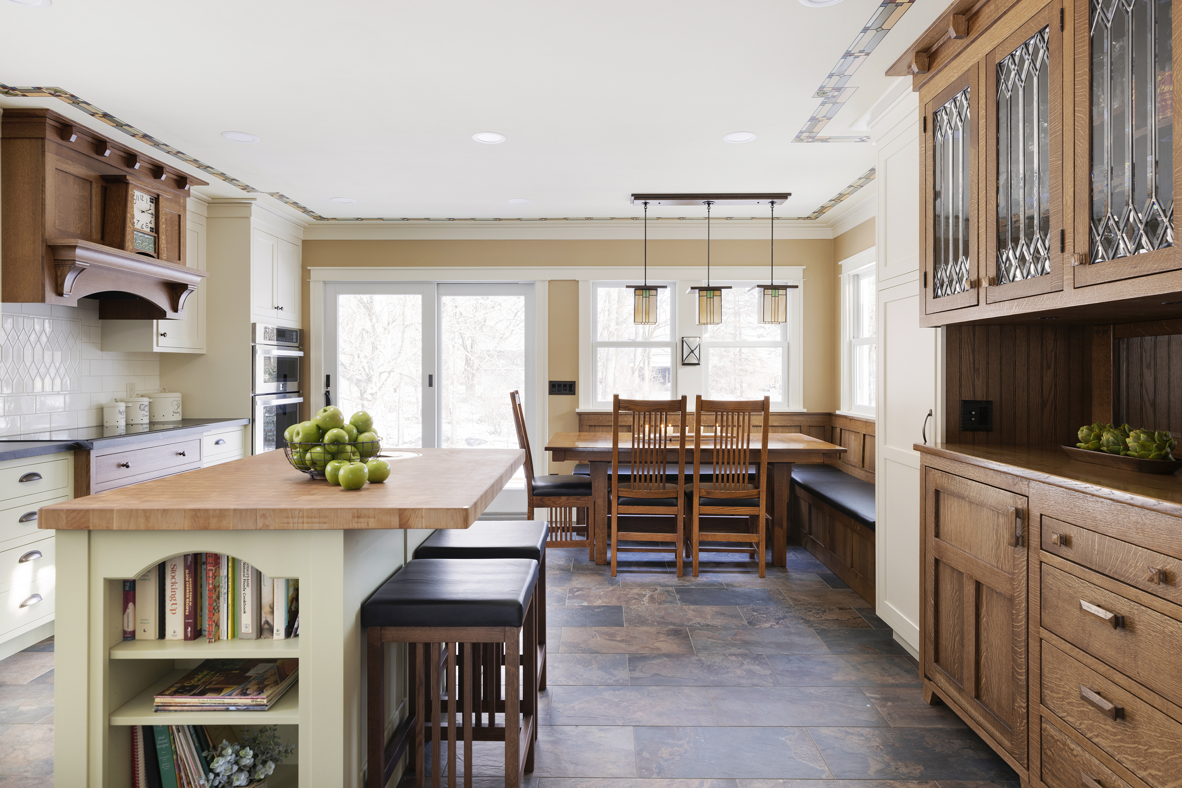 Craftsman kitchen remodel with butcher block island, built in dining seating, and double glass sliding doors