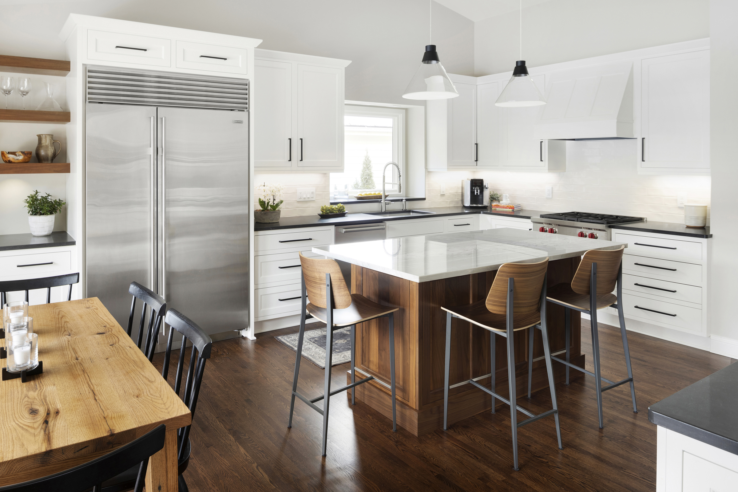 Kitchen with stainless steel appliances, white cabinets, and wood stone accents