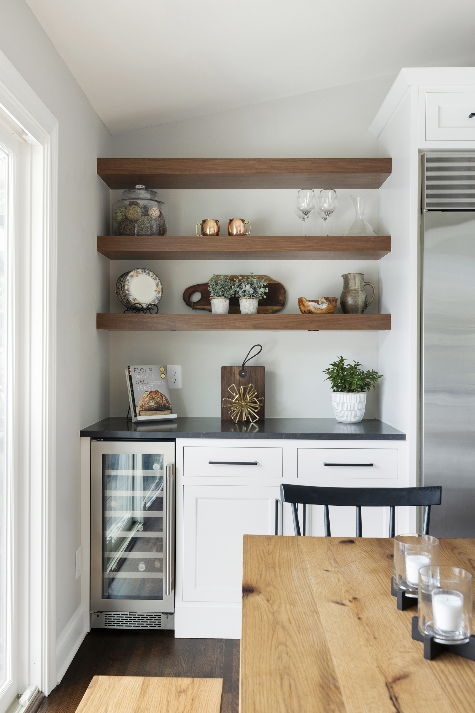 Kitchen with wood floating shelves and white base cabinets