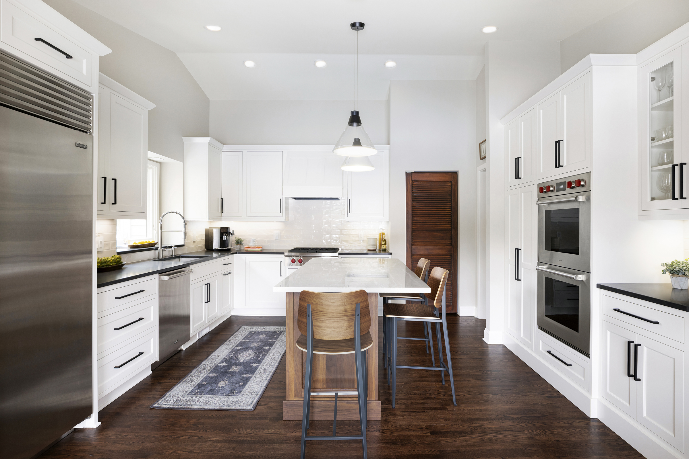 Kitchen with wood tone island and white cabinets