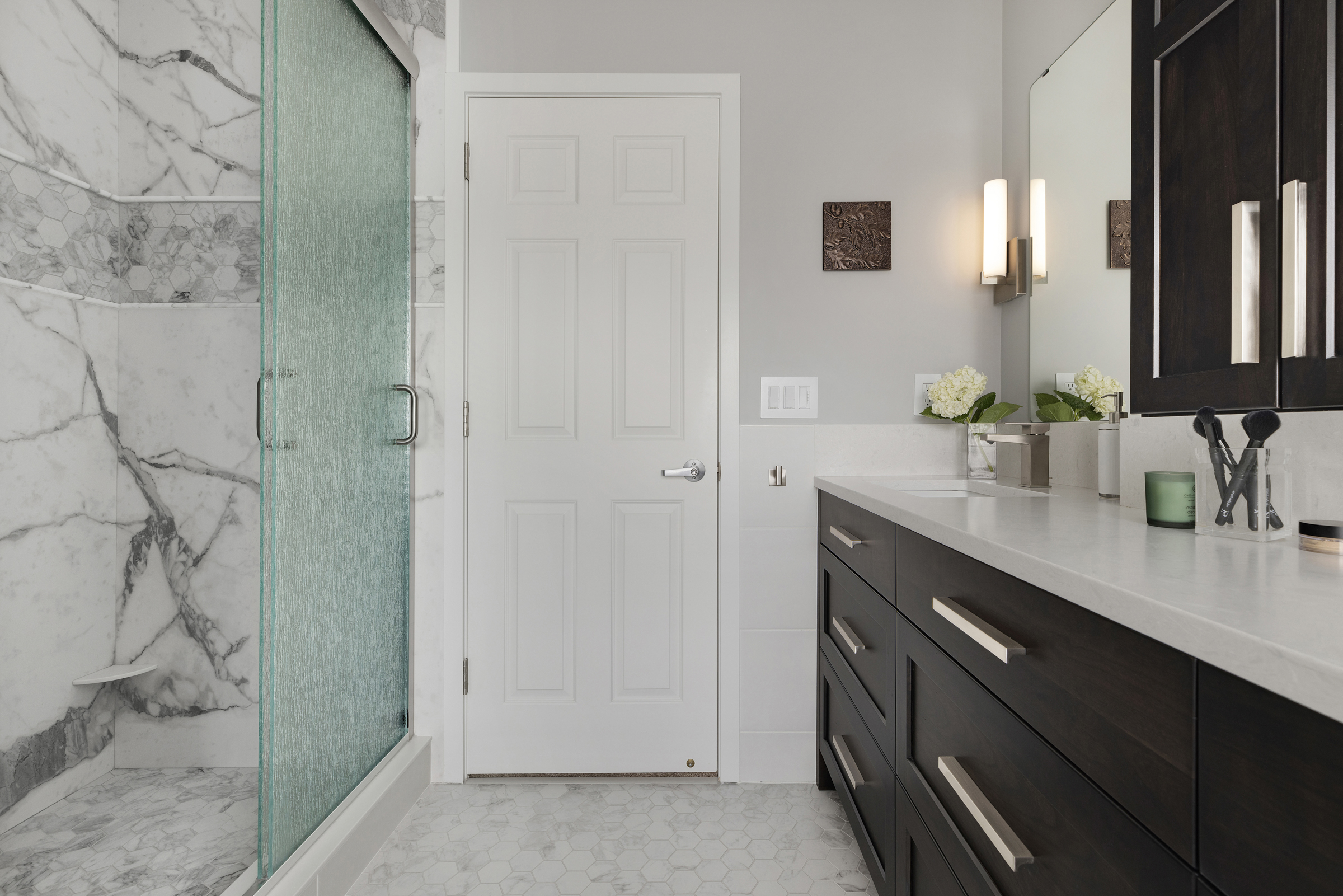 Renovated primary bathroom with large walk in shower and dark wooden vanity