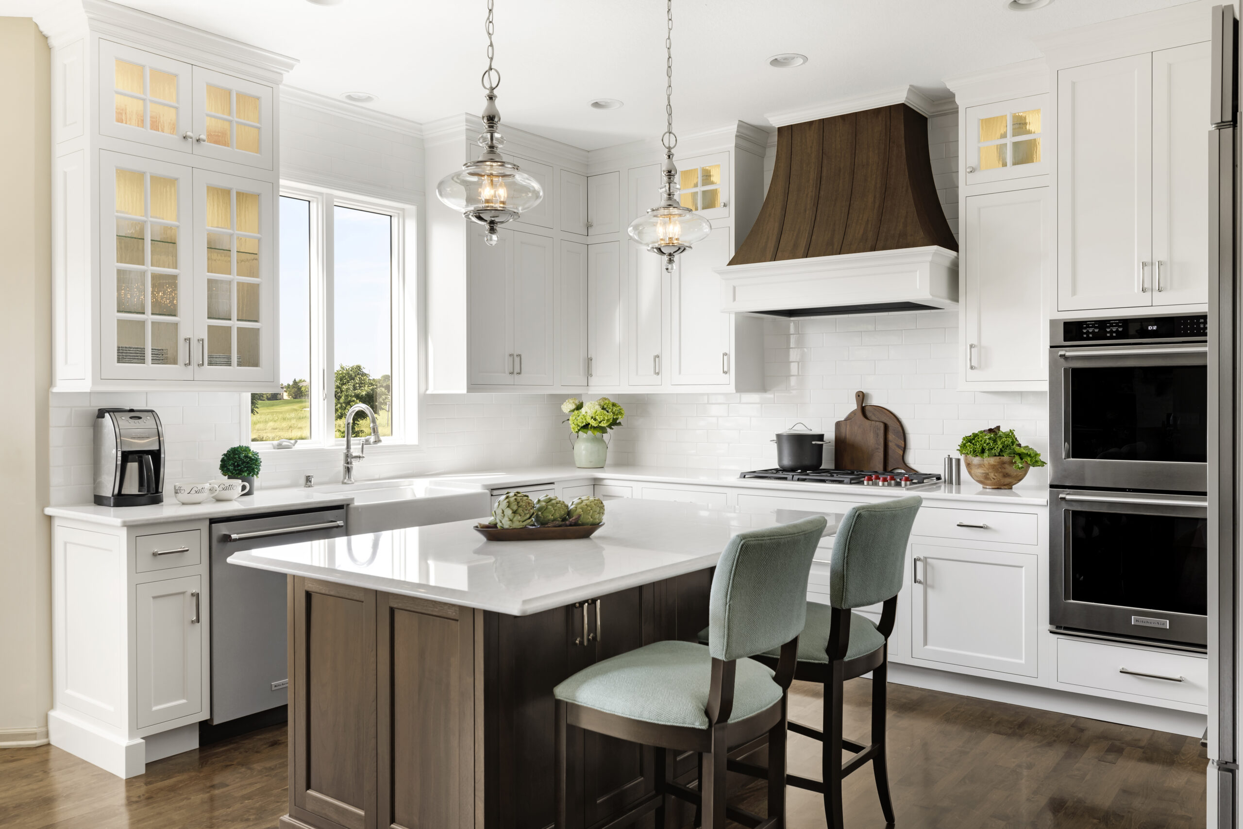 Kitchen remodel with large wooden island and white surrounding cabinets