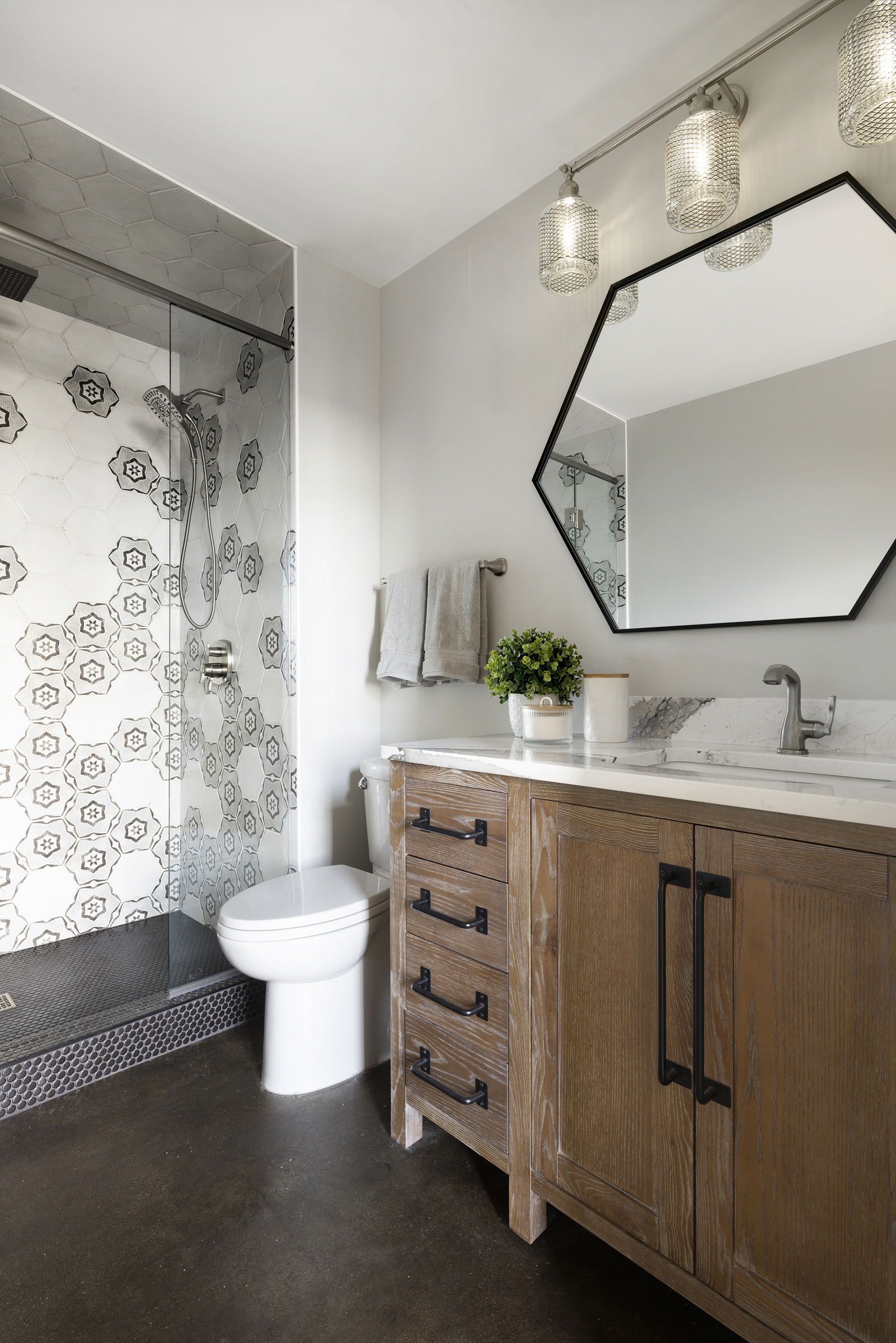 Bathroom renovation with dark floor and wood cabinet