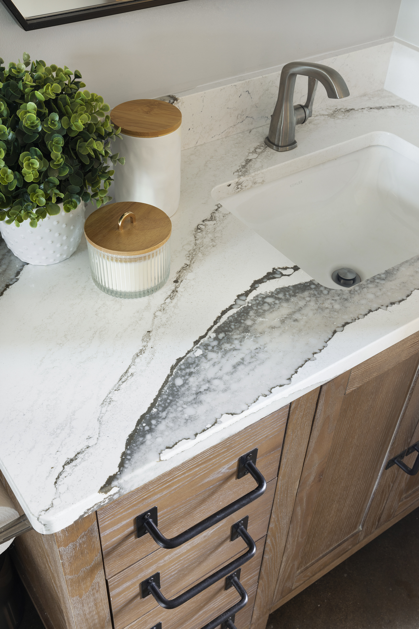 Bathroom counter with large marble pattern and black cabinet pulls