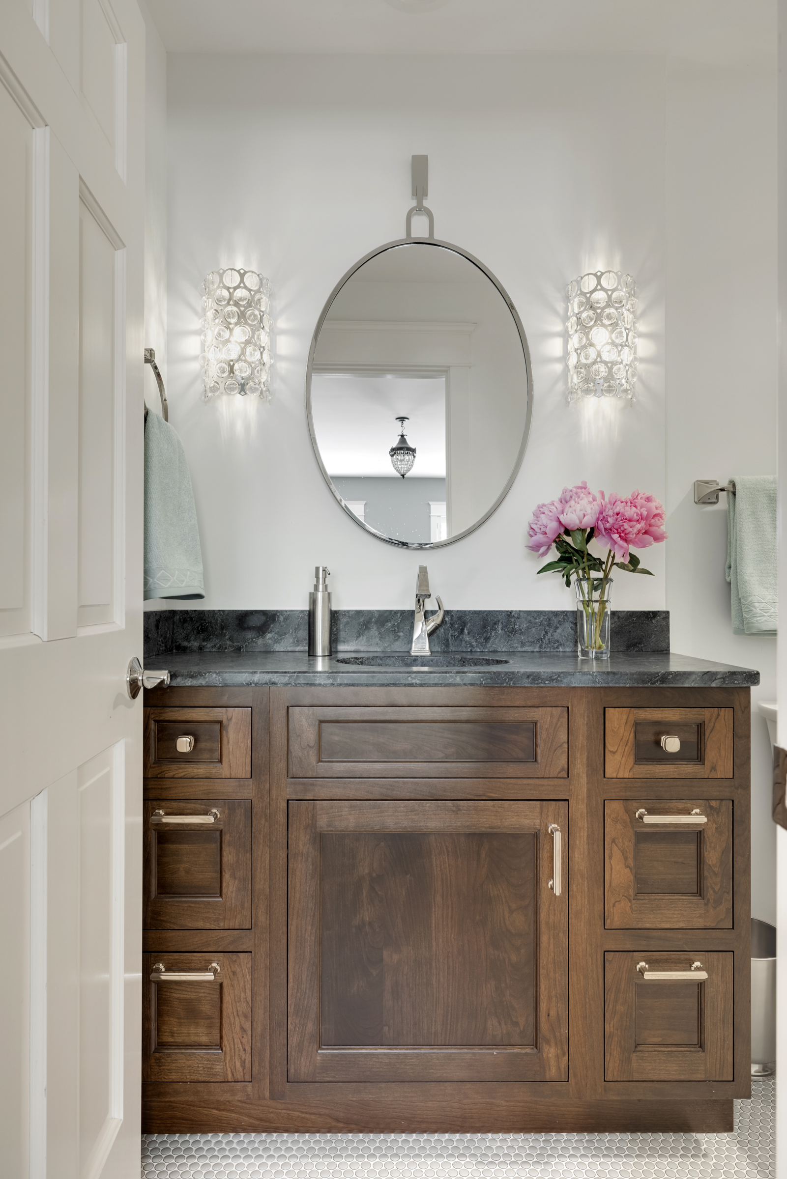 Bathroom remodel with dark wood vanity and black countertop