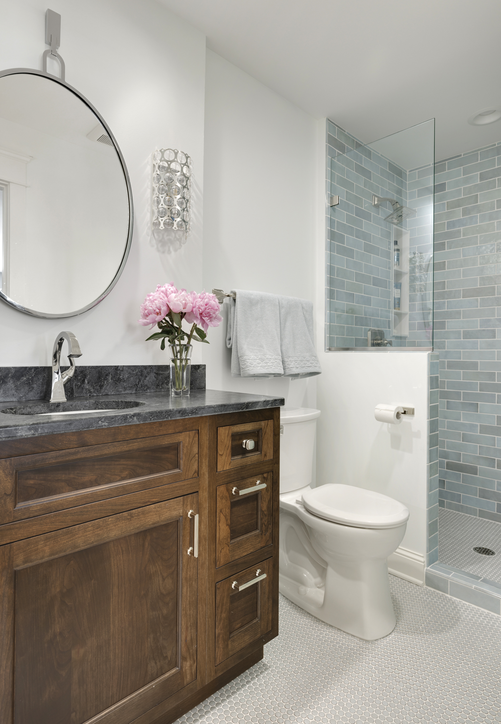 Bathroom remodel with blue shower tile and dark vanity