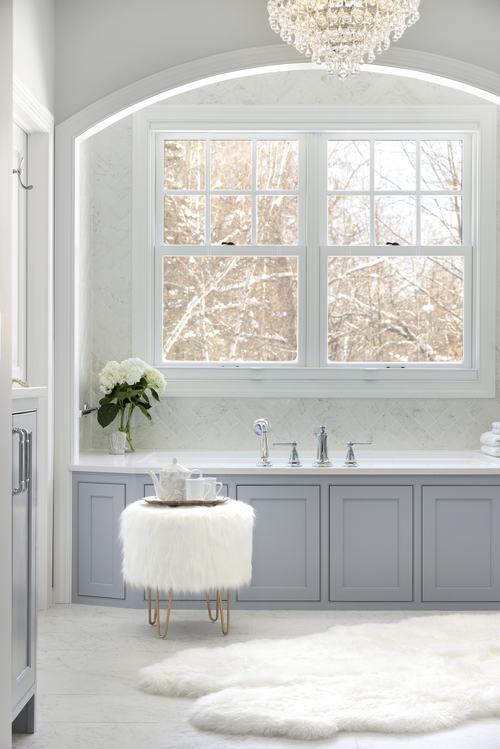 European inspired bathroom remodel with light blue vanity and white tile floor