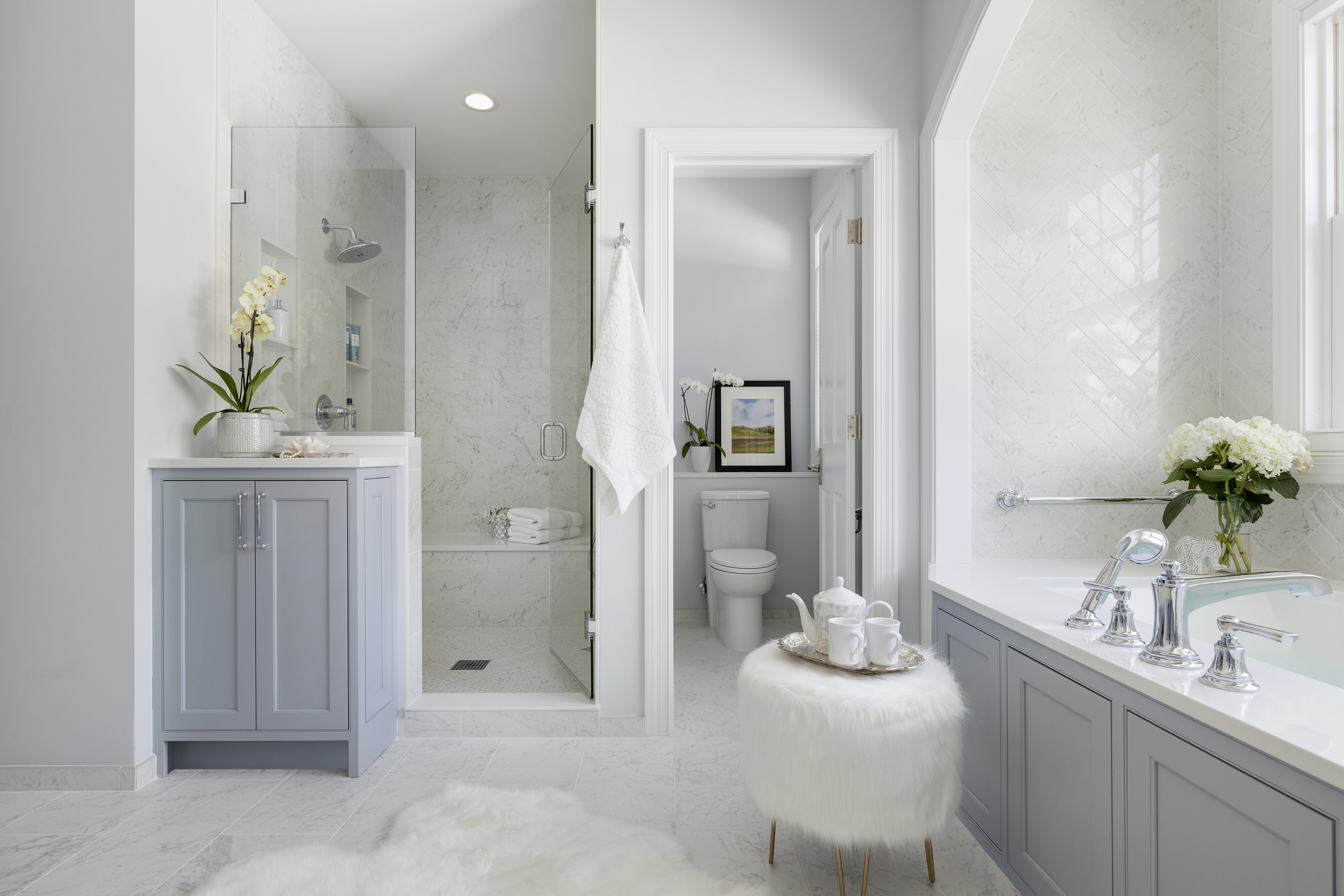 European inspired bathroom remodel with light blue vanity and white tile floor