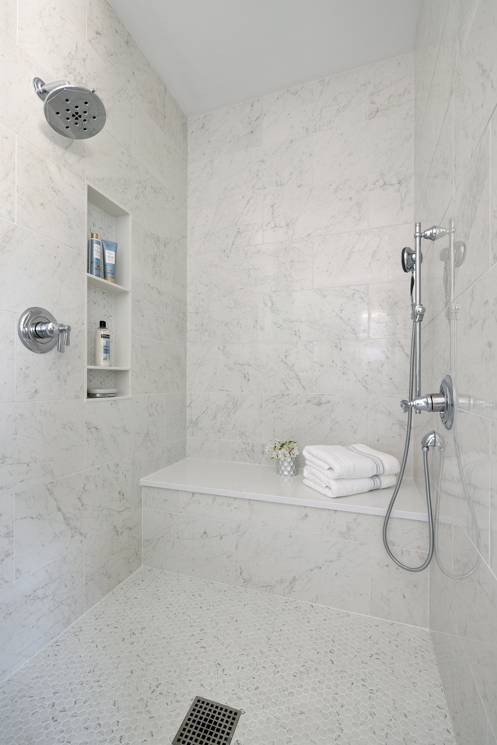 European inspired bathroom remodel with light blue vanity and white tile floor