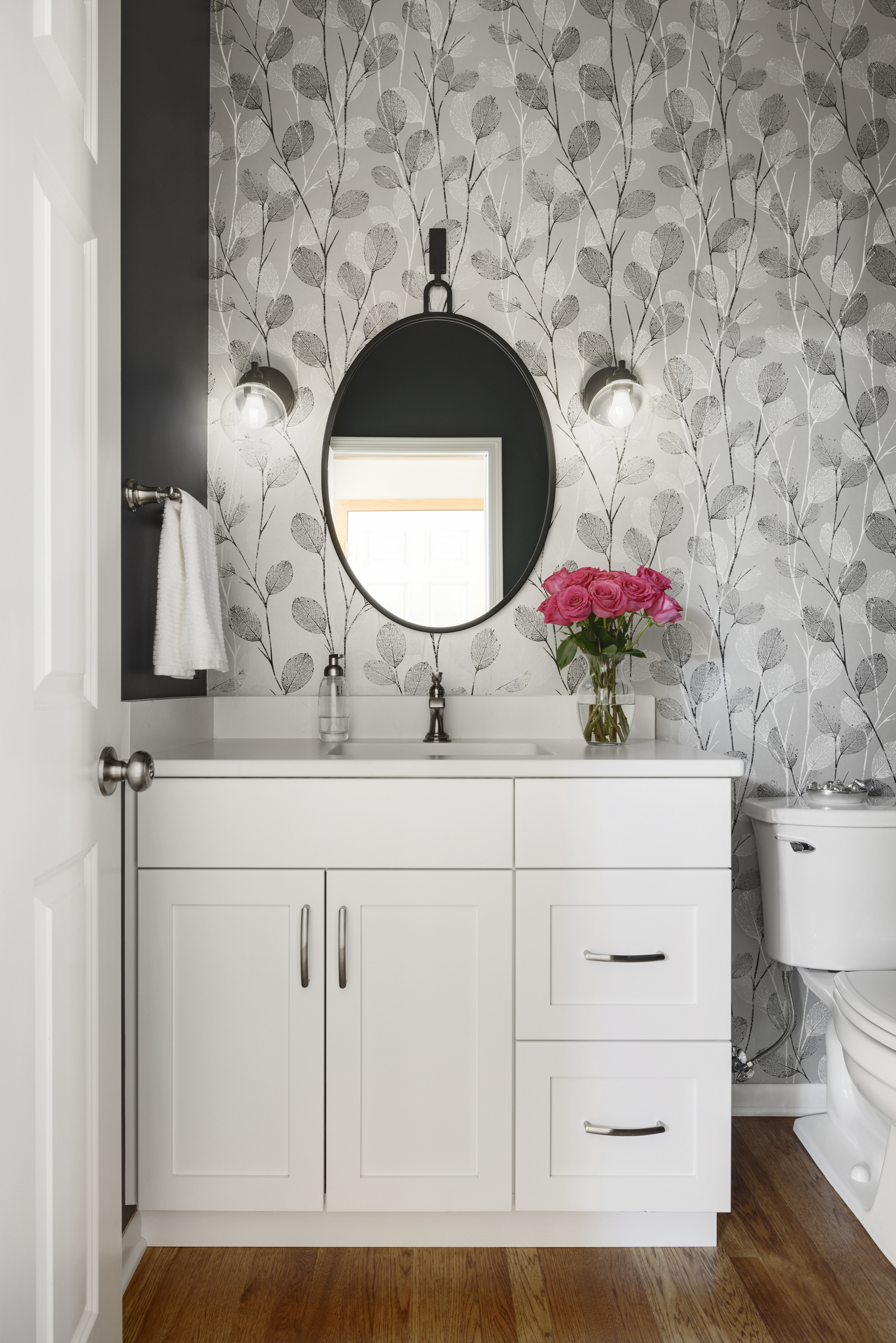 Bold half bathroom renovation with black accent wall and geometric wallpaper