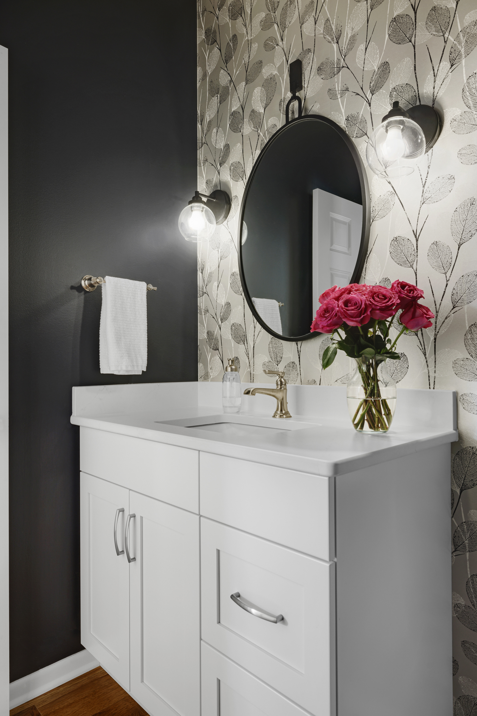 Bold half bathroom renovation with black accent wall and geometric wallpaper