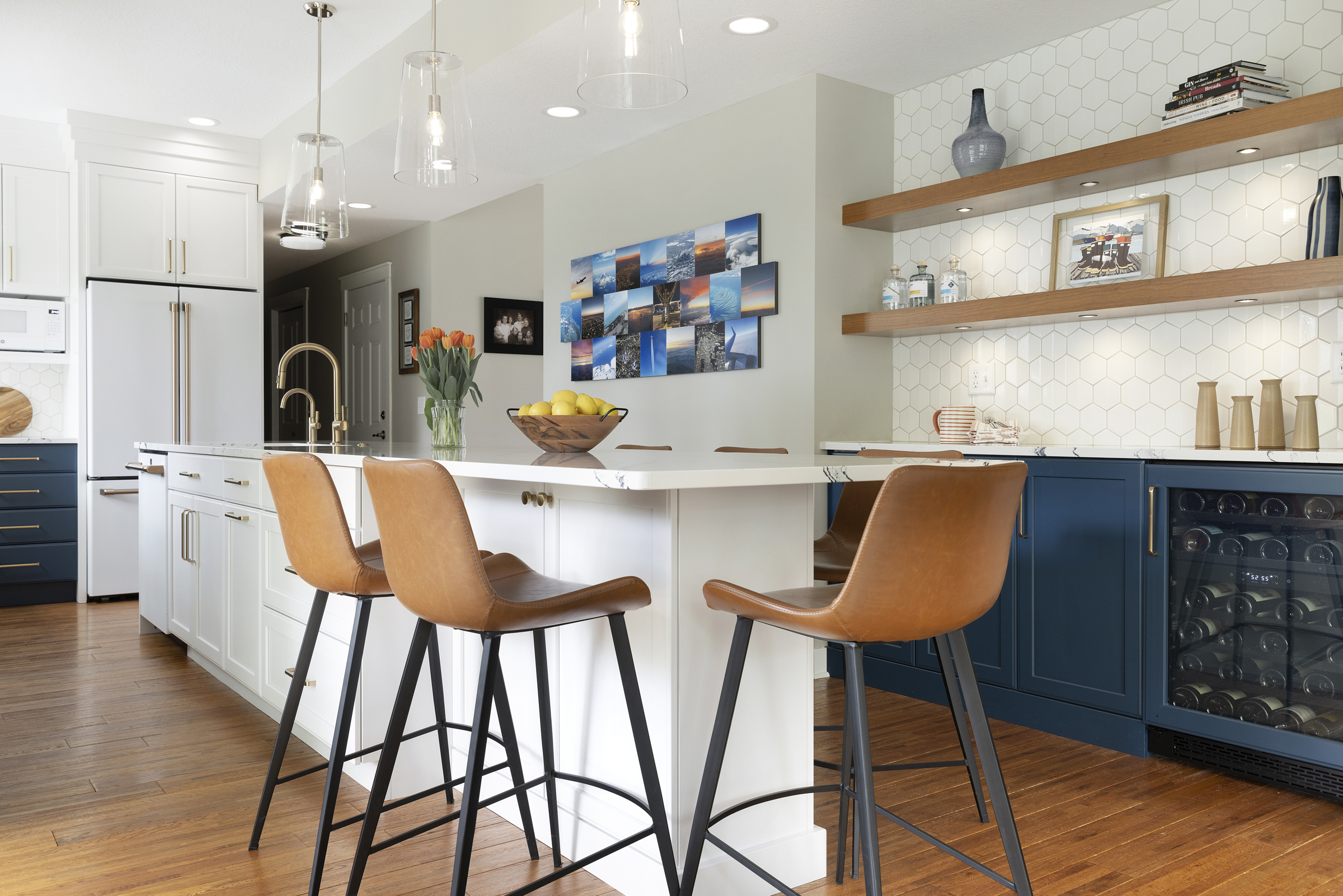 Kitchen remodel with large island with bar stools and wood floating shelves