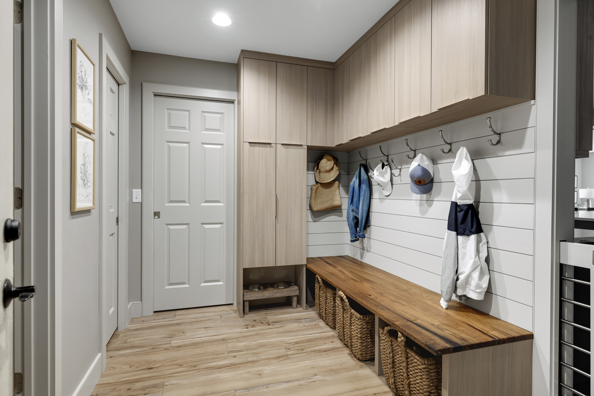 Contemporary mudroom with light wood floor, light wood cabinets, and plenty of storage