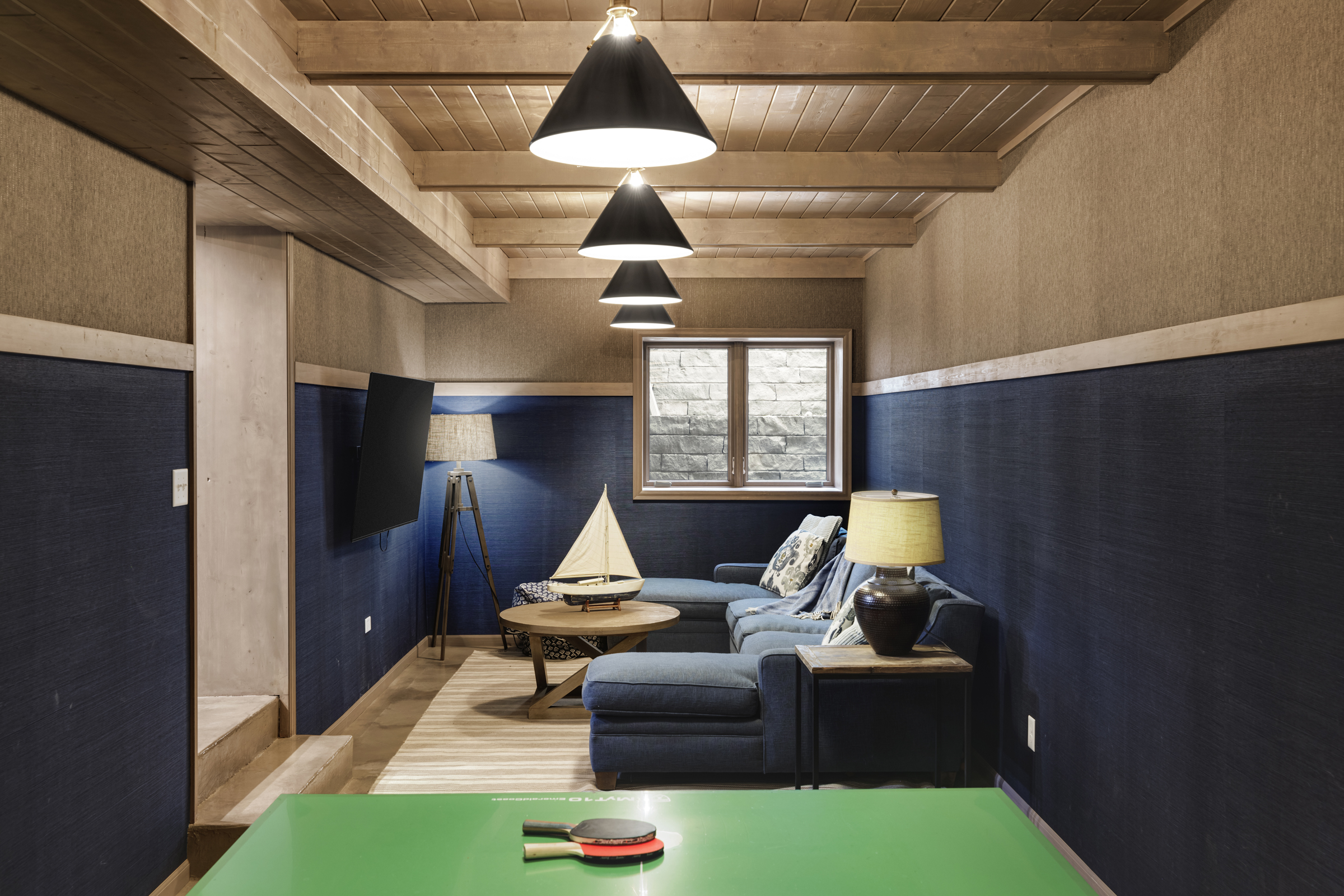 Contemporary lower level addition with dark blue walls and ping pong table