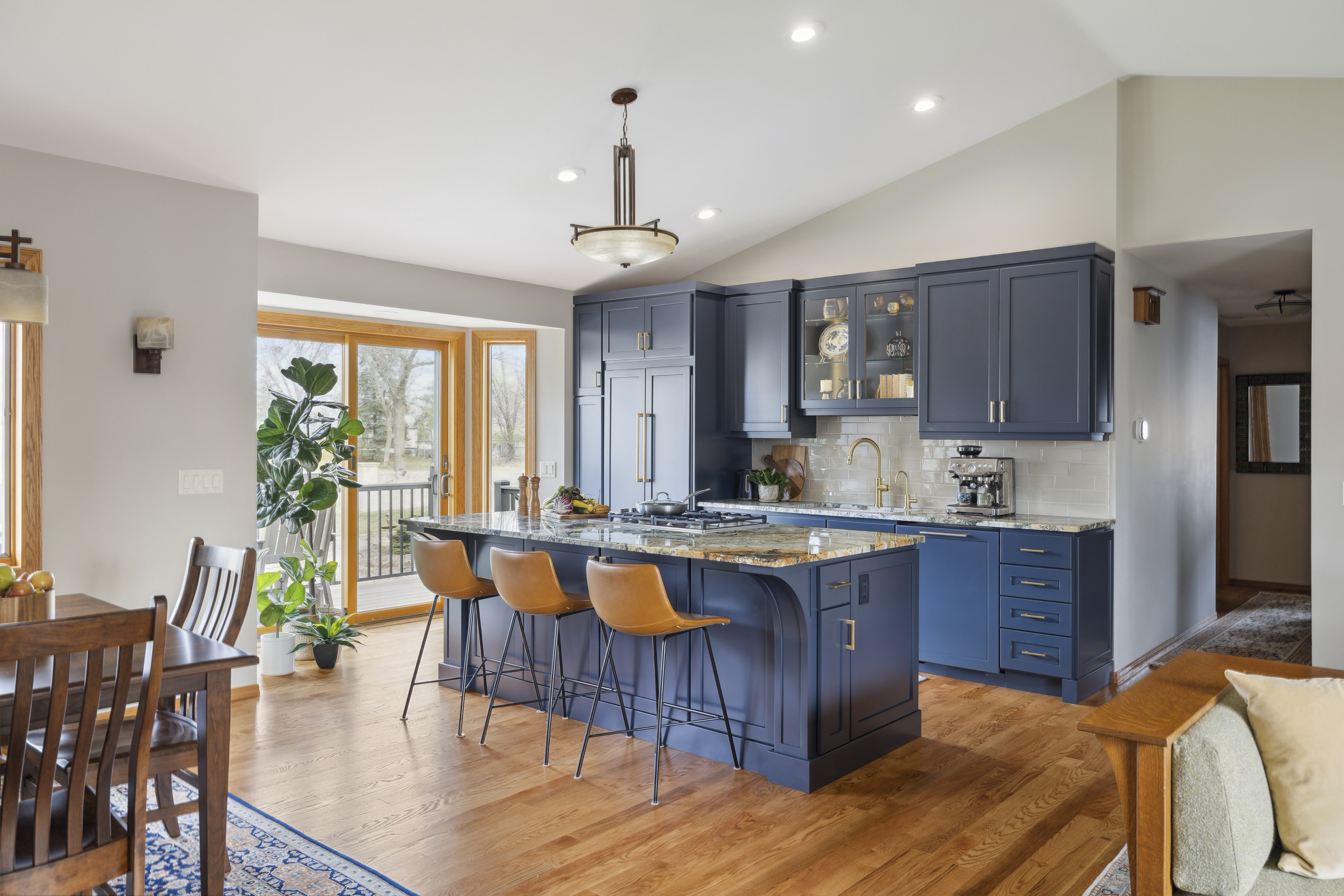 Open kitchen remodel with blue island and cabinets, wood floor, and tall vaulted ceilings