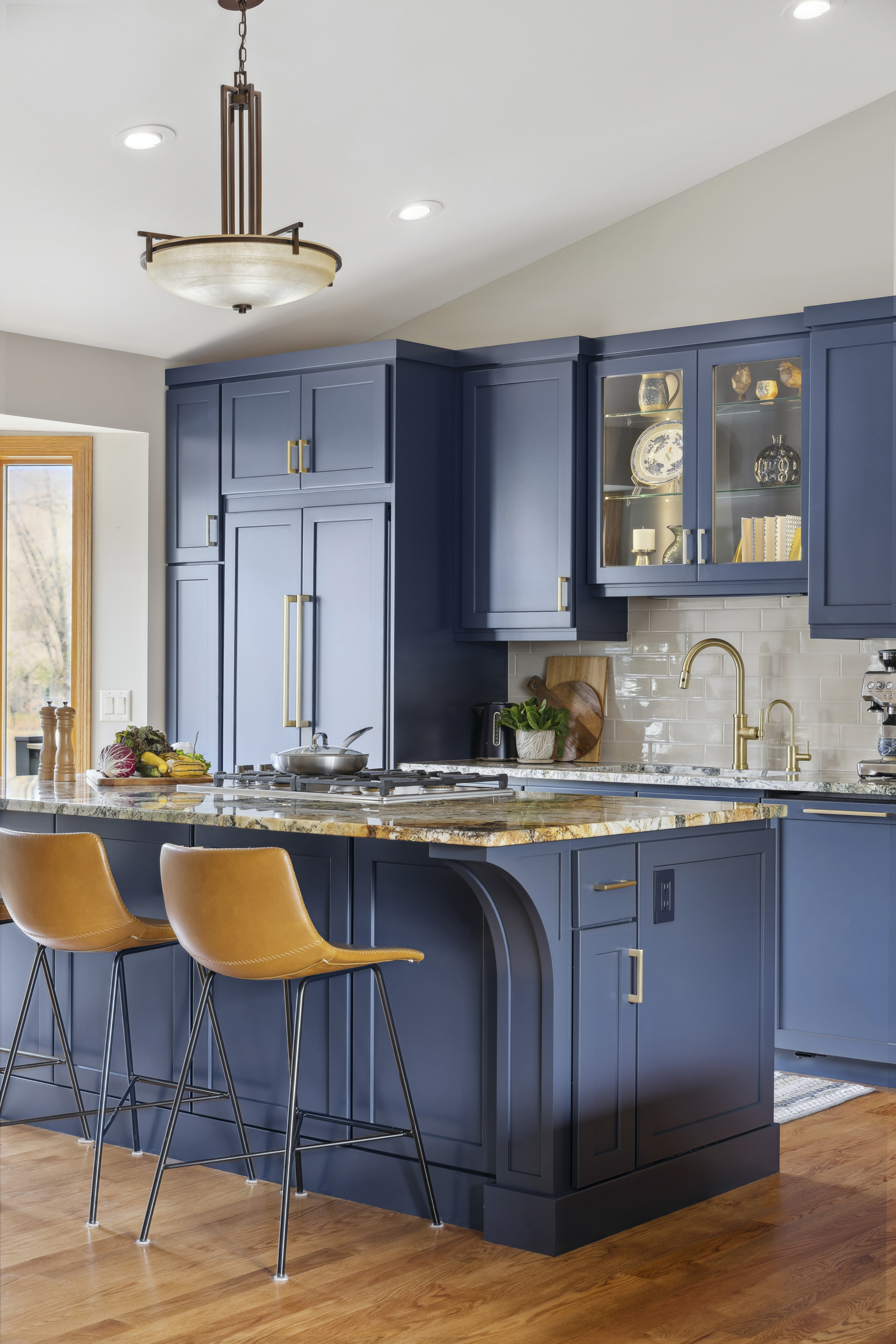 Kitchen remodel with blue cabinets, medium toned wood floor, and open floor plan