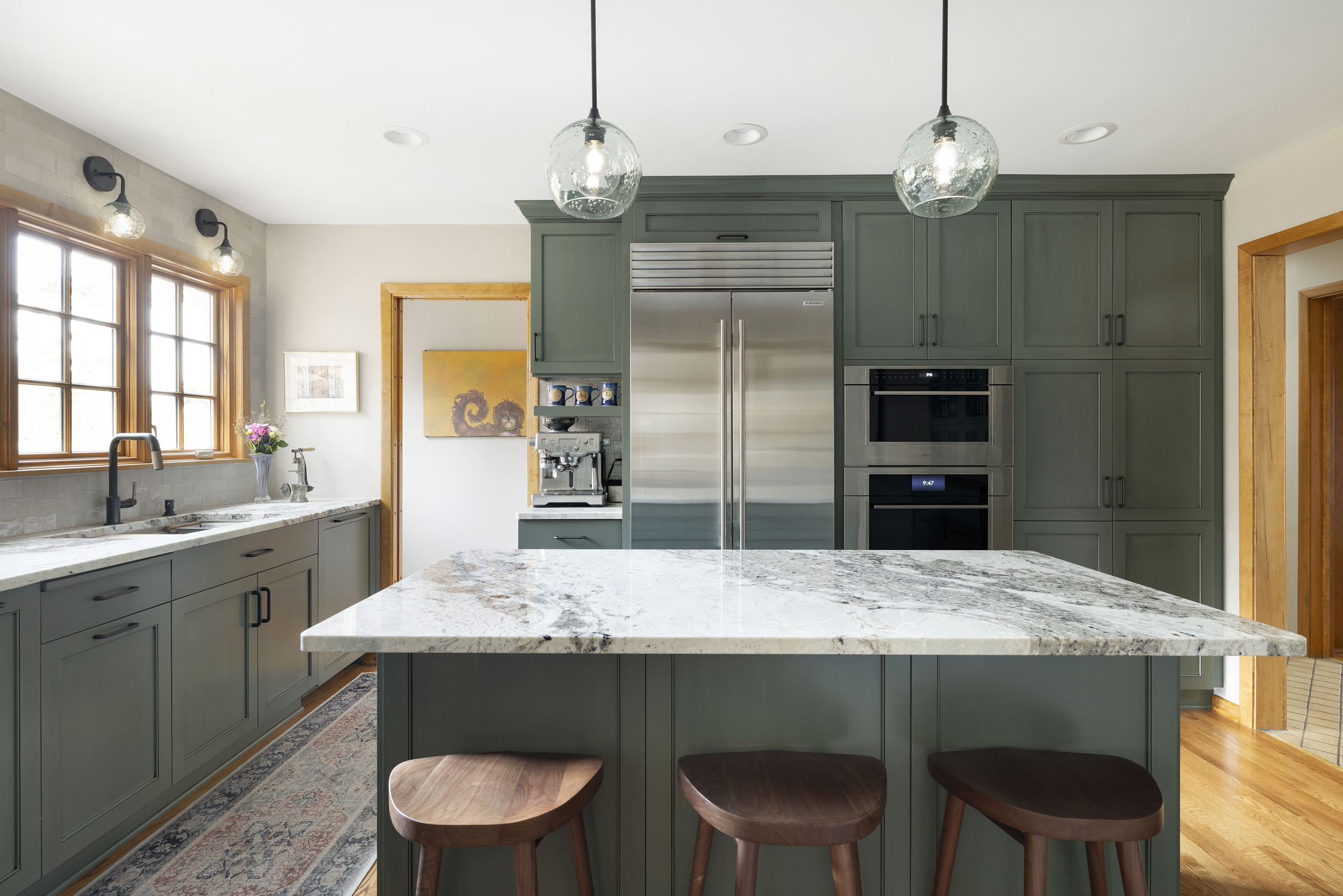 Kitchen remodel with green cabinets, wood accents, and beautiful marble countertops