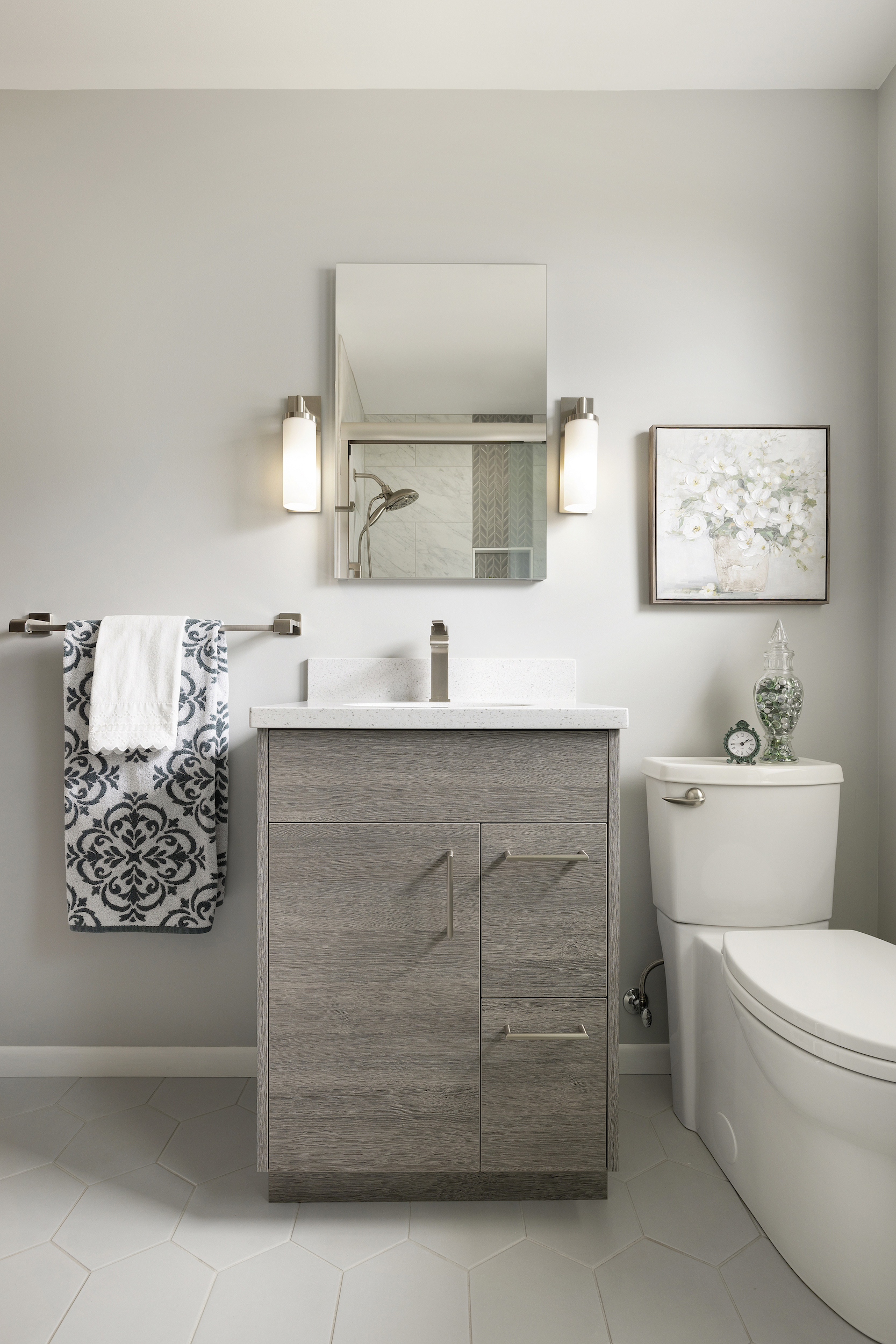 bathroom remodel with gray wood cabinet and frameless mirror