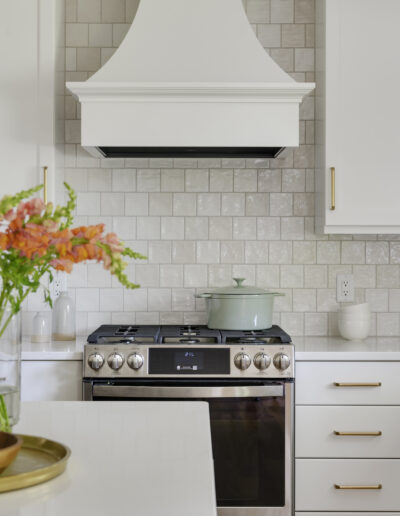 Kitchen remodel with warm wood floors, light green island, and white cabinets